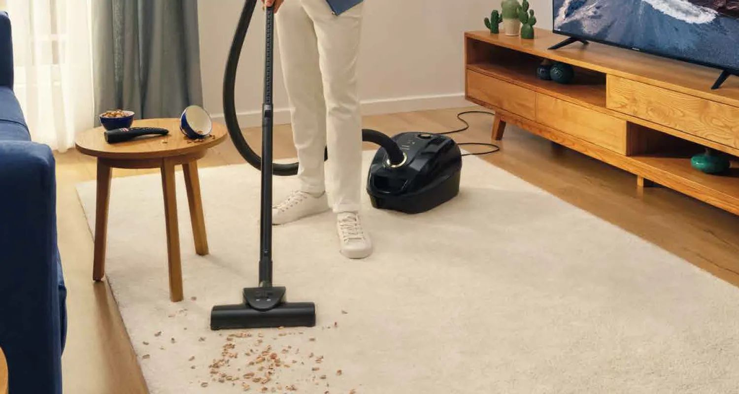 Elektrikli süpürge ile temizlik yapan insan